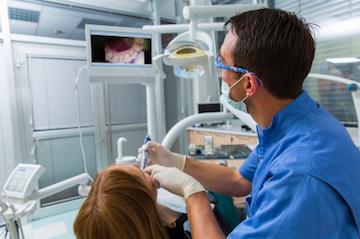 dentist performing a routine dental cleaning on patient