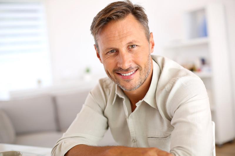 man smiling after getting dental crowns