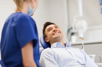 man sitting in dental chair after dental emergency